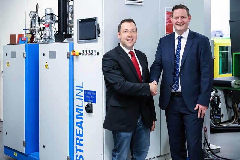 The new high-pressure metering machine STREAMLINE for the surface treatment of plastic moulded parts with the two engineers responsible for the surface project, Mr. Dominik Malecha from the Plastics Institute for SMEs (K.I.M.W.) in Lüdenscheid and Mr. Alexander Frank, Hennecke GmbH (from left to right) The new high-pressure metering machine STREAMLINE for the surface treatment of plastic moulded parts with the two engineers responsible for the surface project, Mr. Dominik Malecha from the Plastics Institute for SMEs (K.I.M.W.) in Lüdenscheid and Mr. Alexander Frank, Hennecke GmbH (from left to right)